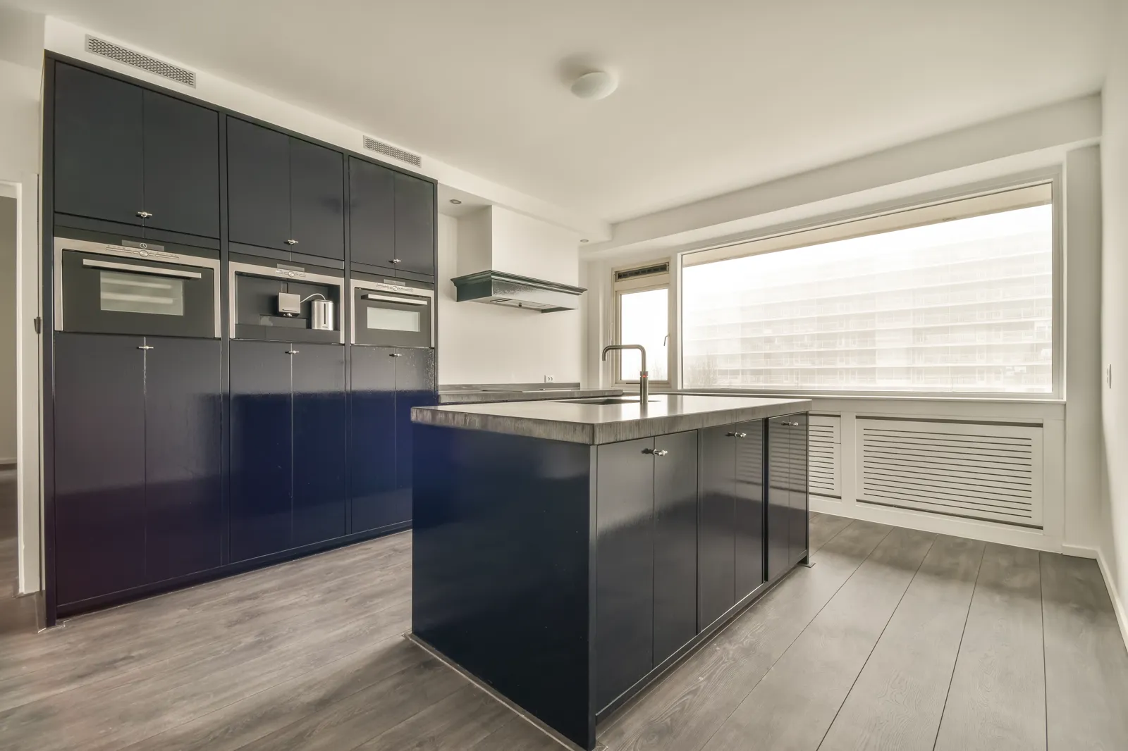 Kitchen with deep navy painted cabinets and a white island