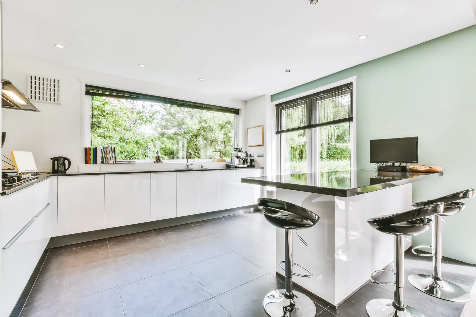 White painted kitchen cabinets with a long island and bar stools