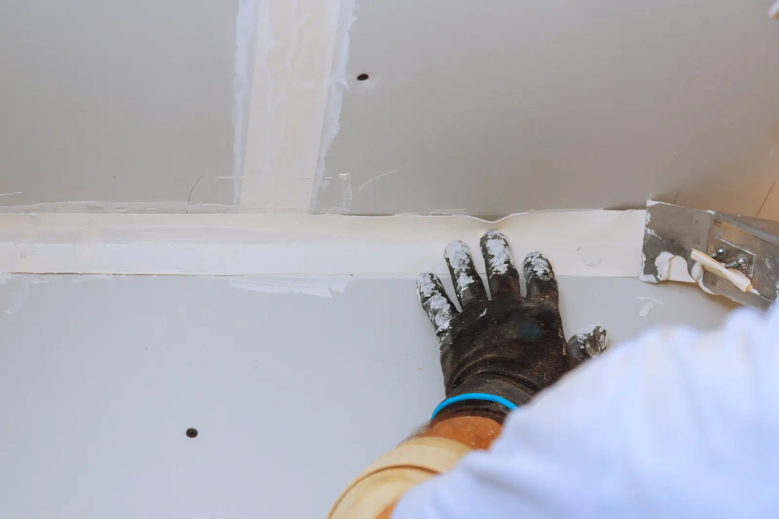 Drywall seam being taped and patched before paint