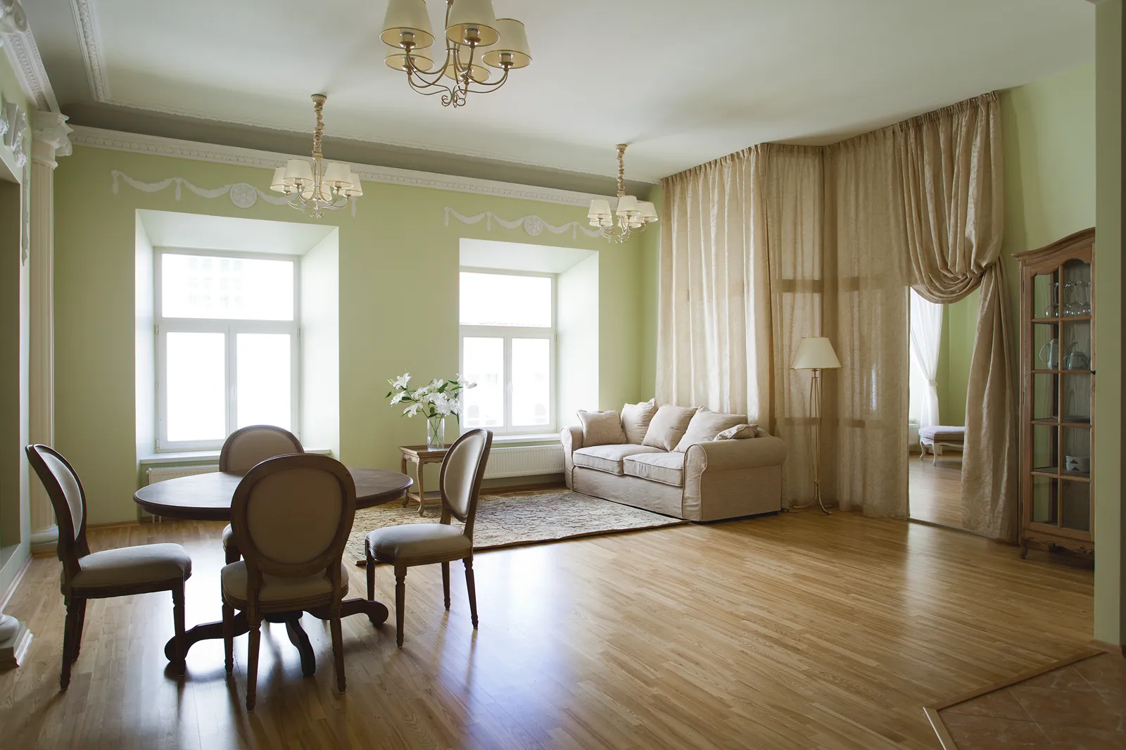 Classic room with soft sage walls, crown molding and tall windows