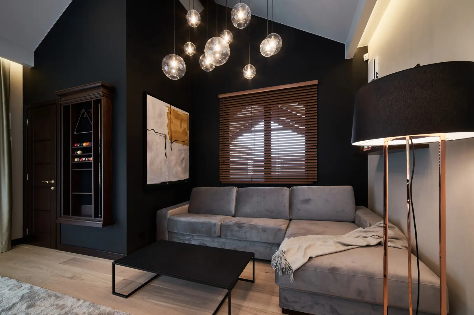 Living room with deep charcoal painted walls, white trim and pendant lights