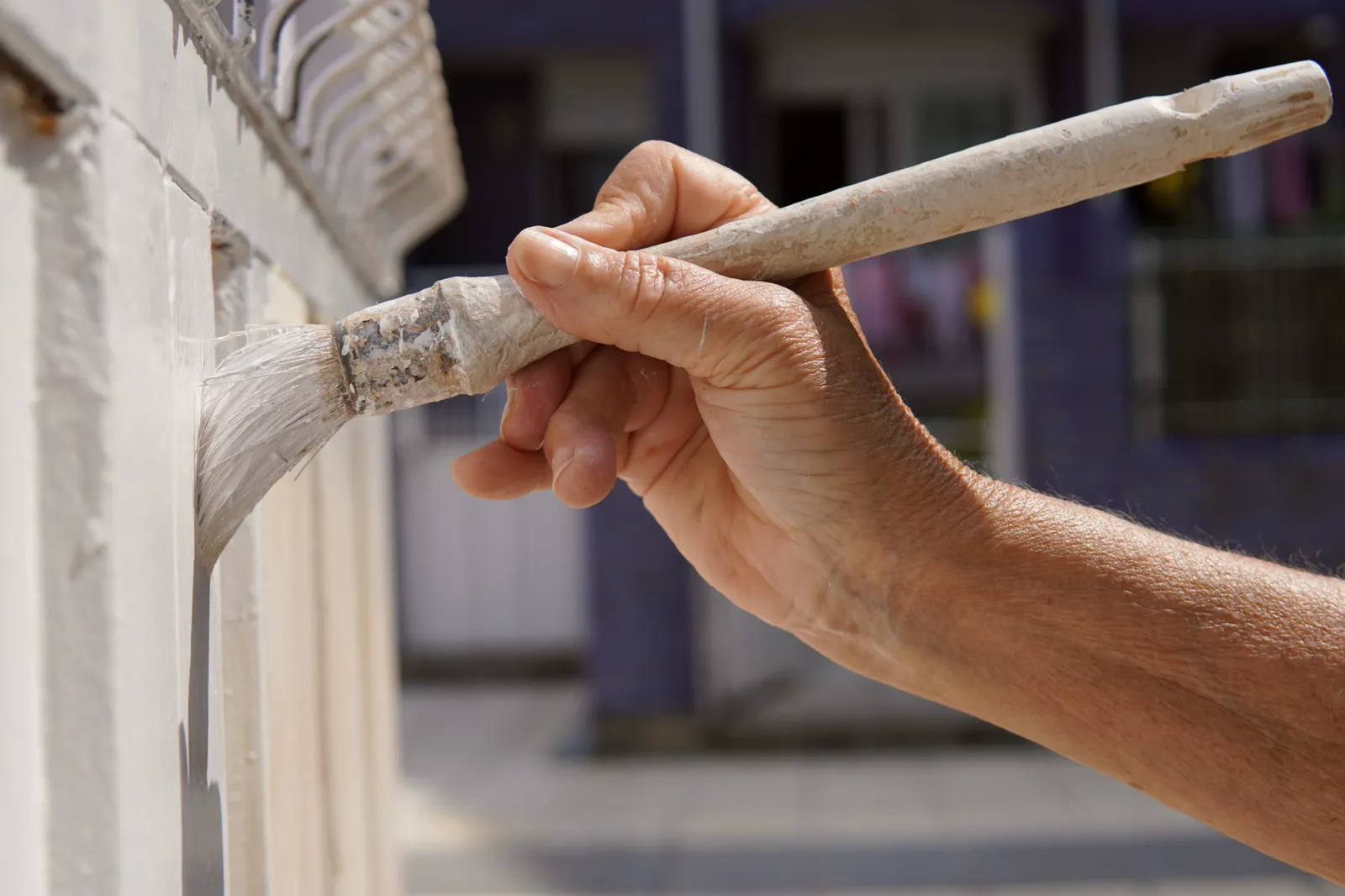 Hand brushing white paint onto wood trim