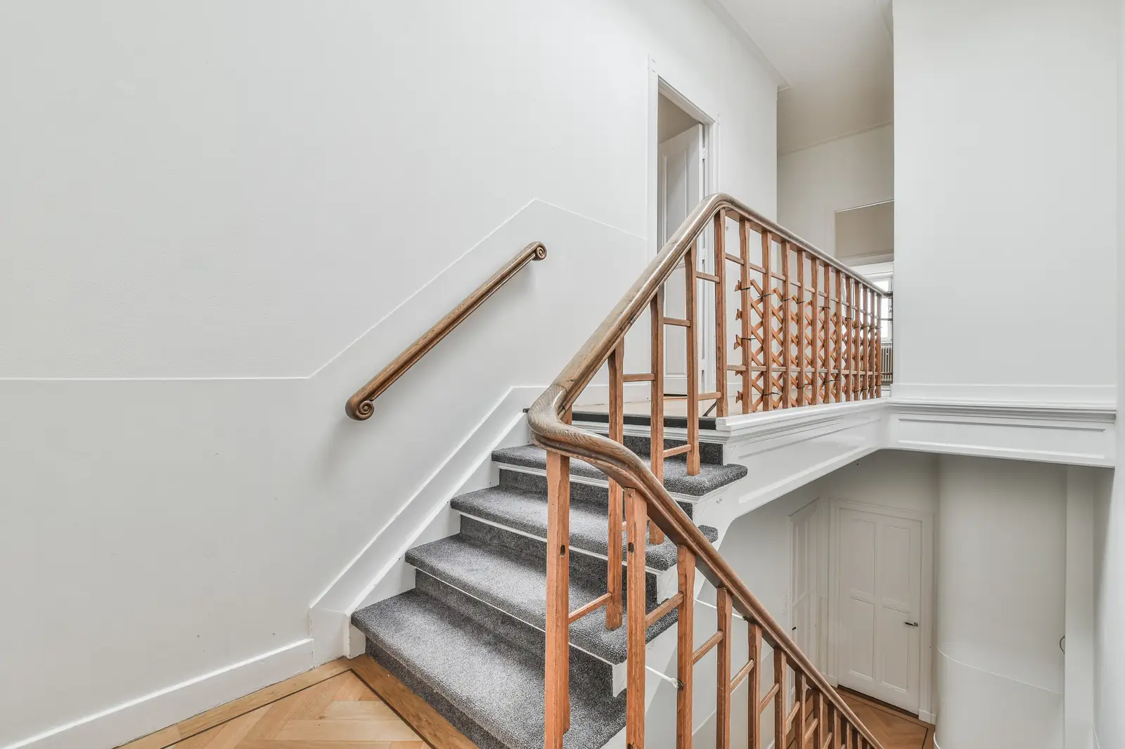 Stained wood stair railing and handrail in a bright stairwell